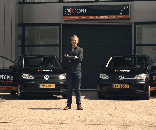 Man standing in front of two Volkswagen Ups with EU-People wrapping