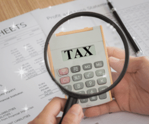 Holding a magnifying glass over a calculator with TAX on the screen